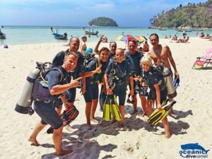 A group of excited divers pose for pictures before entering the water for their dive.